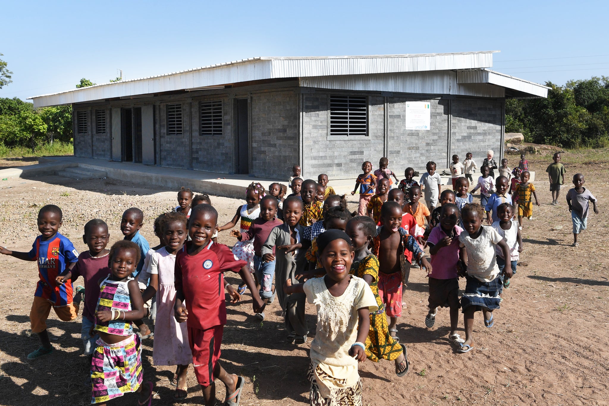 Children in front of a recycled bricks classroom.